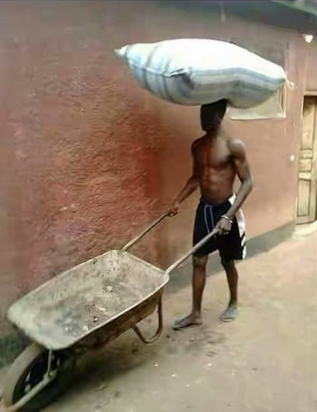 Black man uses his head to carry stuff - Work smart