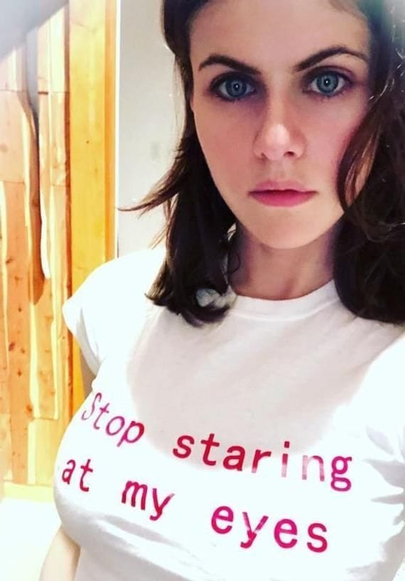 Girl wearing a T-shirt that says "Stop staring at my eyes"